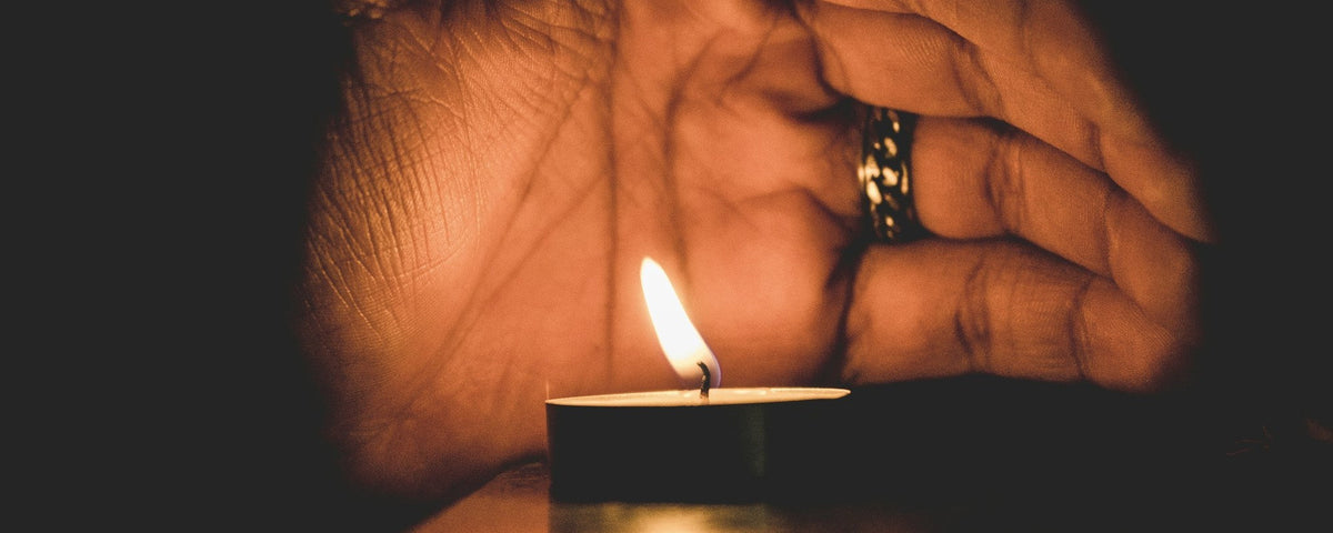 Accendino per anziani: una mano anziana con un anello ripara un lumino acceso